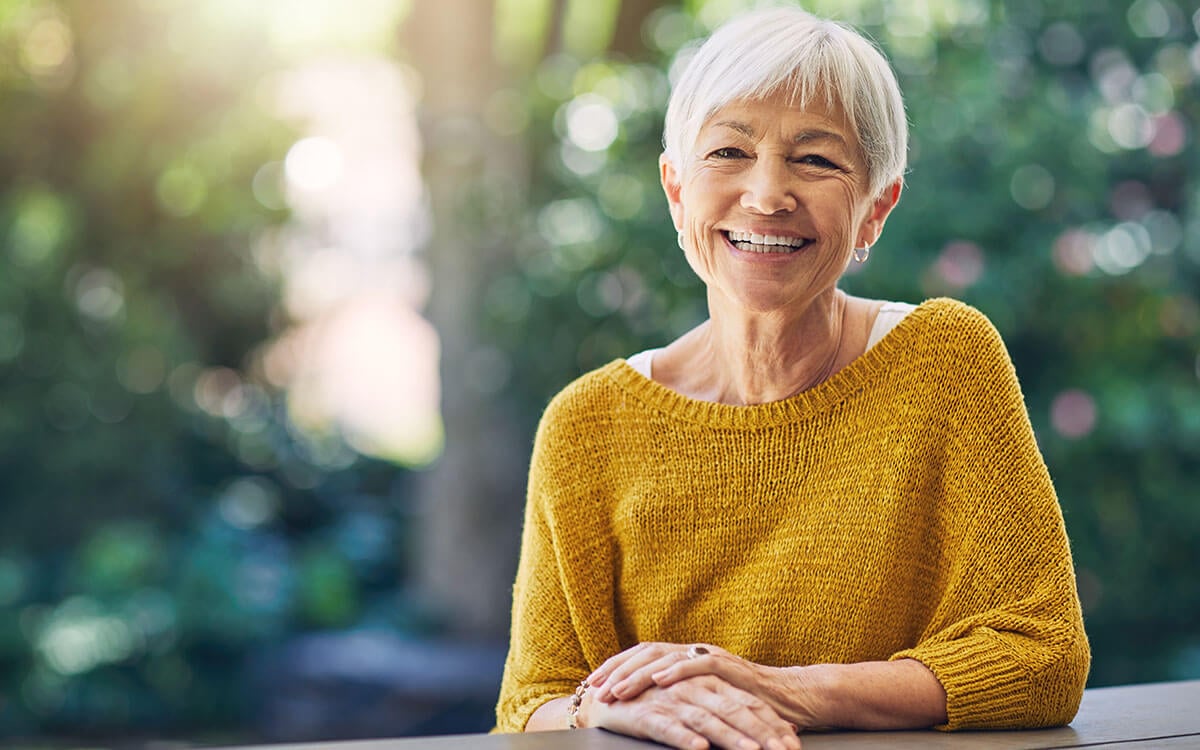 happy senior woman sitting at a table